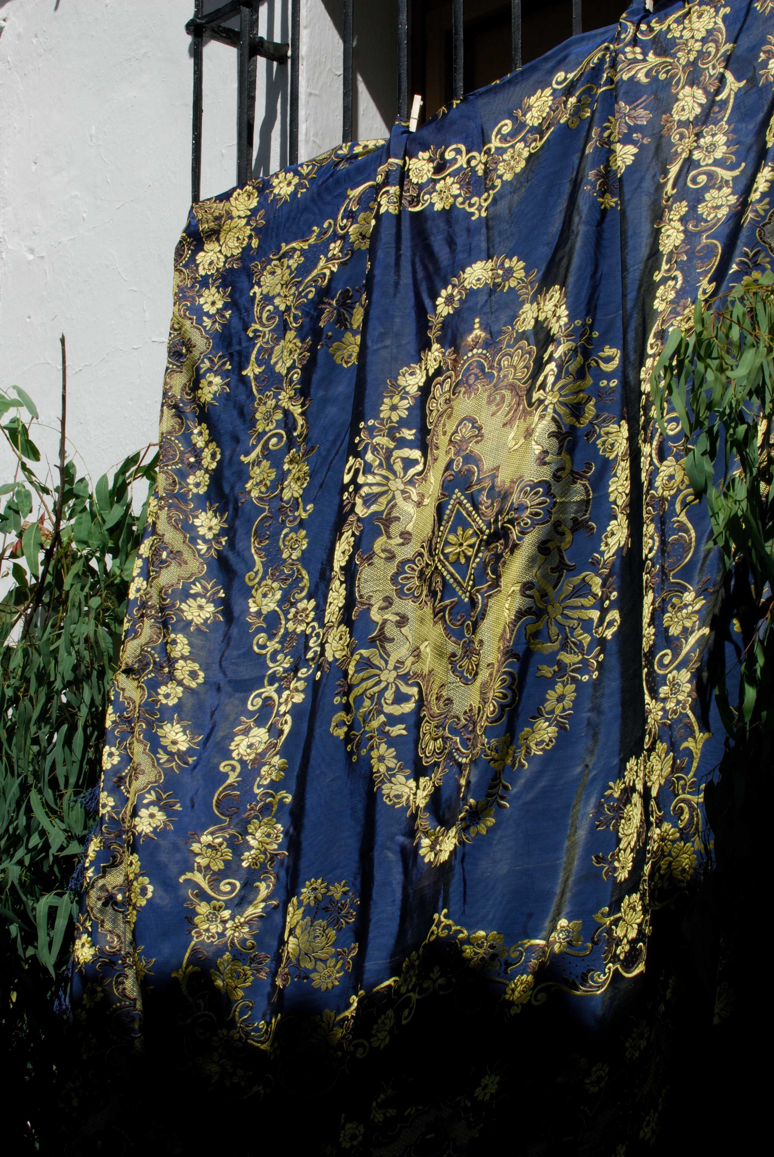 Imagen de un mant&oacute;n colgando de un balc&oacute;n para decorar las calles en el d&iacute;a del Corpus.